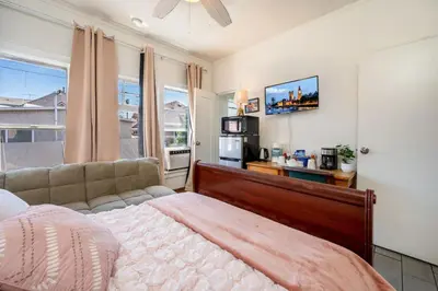 a bedroom with a bed and a couch and a tv at Sleek Studio Near Downtown LA • AC • WiFi • Snacks in Los Angeles