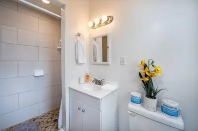 a white bathroom with a sink and a mirror at Comfy Studio Near Downtown LA with AC WiFi and Snacks in Los Angeles
