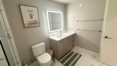 a bathroom with a toilet and a sink and a mirror at Beautiful NEW apartment in SM! in Los Angeles