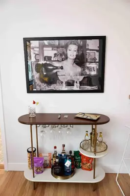 a tv hanging on a wall above a table with drinks at Lalaland Bungalow in Burbank
