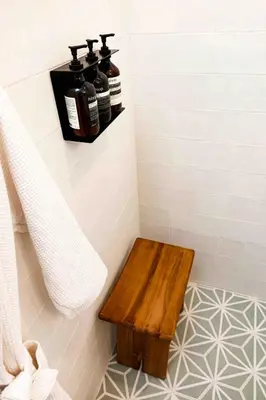 a bathroom with a wooden bench in a shower at Lalaland Bungalow in Burbank