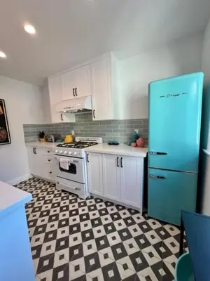 a kitchen with a blue refrigerator and a checkered floor at Lalaland Bungalow in Burbank