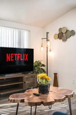 a living room with a television and a table with flowers at Foothills LA Hideaway Patio Lounge Work-Friendly in Glendora