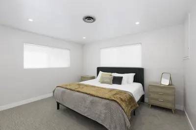 a white bedroom with a bed and a night stand at Bear Mountain Getaway in Big Bear Lake
