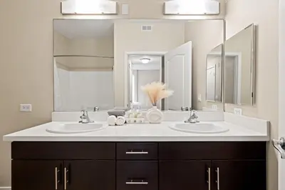 a bathroom with two sinks and a large mirror at Great 2bd 2bath in MdR! Free parking and pool! in Los Angeles