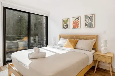 a bedroom with a large bed and a large window at Luna View LA in Los Angeles