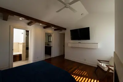 a bedroom with a bed and a flat screen tv at Venice Beach Townhouse in Los Angeles