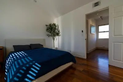 a bedroom with a bed with a blue blanket on it at Venice Beach Townhouse in Los Angeles