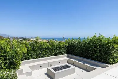 a bench sitting on top of a sidewalk with bushes at Luxurious Malibu 6BR Estate with Pool, Theatre, Views in Malibu Beach