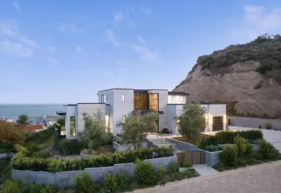 a large white house with a hill in the background at Luxurious Malibu 6BR Estate with Pool, Theatre, Views in Malibu Beach