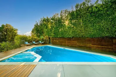 a swimming pool in front of a brick wall at Stunning Modern Estate in BH with Pool, Spa, and Views in Los Angeles