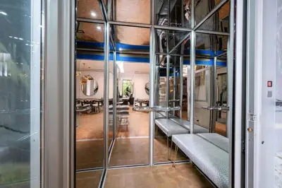 a room with a glass wall with benches and a table at Ultra Luxurious Villa in the Beverly Hills Flats in Los Angeles