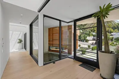 a house with glass walls and a potted plant at Prestigious 6BR BH Mansion W. Pool, Theatre, Views in Los Angeles