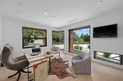 a living room with a desk and chairs and a tv at Prestigious 6BR BH Mansion W. Pool, Theatre, Views in Los Angeles