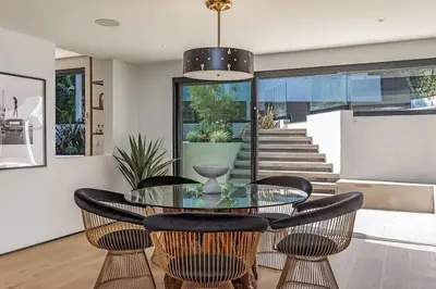 a dining room with a glass table and chairs at Sunset Plaza Luxury Masterpiece Villa in Los Angeles