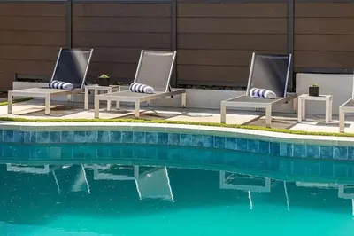 two lounge chairs sitting next to a swimming pool at Sunset Plaza Luxury Masterpiece Villa in Los Angeles