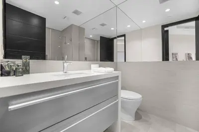 a bathroom with a sink and a toilet and a mirror at Prestigious Hillside Villa W. Pool, Theater, Views in Los Angeles
