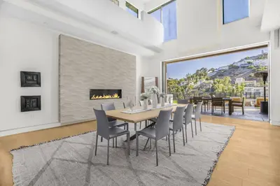 a dining room with a table and chairs and a fireplace at Prestigious Hillside Villa W. Pool, Theater, Views in Los Angeles