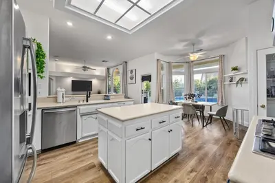 a large kitchen with white cabinets and a table at Corporate & Family Retreat Seven Oaks Pool Home in Bakersfield