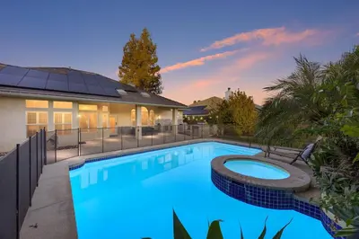 a swimming pool in front of a house at Corporate & Family Retreat Seven Oaks Pool Home in Bakersfield