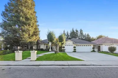 a house with a driveway and a white garage at Corporate & Family Retreat Seven Oaks Pool Home in Bakersfield