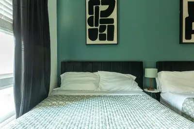a bedroom with two beds and a blue wall at Modern Serenity Apartment for a Comfortable Stay in Glendale