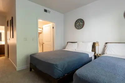 a bedroom with two beds and a clock on the wall at Cozy and Calm Retreat in Heart of Glendale in Glendale