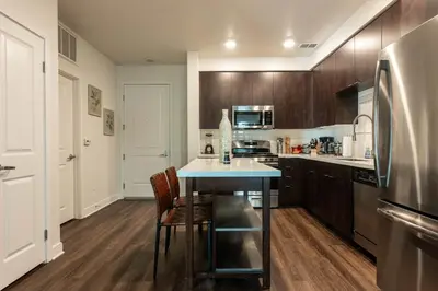 a kitchen with a table and a stainless steel refrigerator at Cozy and Calm Retreat in Heart of Glendale in Glendale