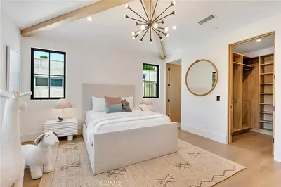 a white bedroom with a large bed and a mirror at Studio City Luxury 6BR Home with Pool and Theatre in Los Angeles