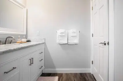 a white bathroom with a sink and a mirror at Cozy 1BR Guest House with Mountain View in Simi Valley in Simi Valley