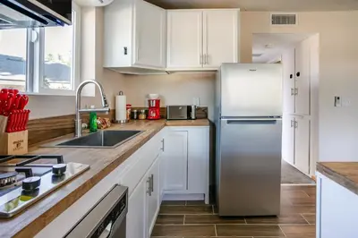 a kitchen with white cabinets and a stainless steel refrigerator at Cozy 1BR Guest House with Mountain View in Simi Valley in Simi Valley