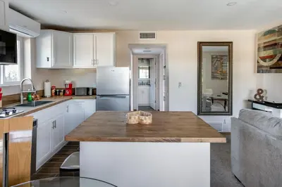 a kitchen with white cabinets and a wooden counter top at Cozy 1BR Guest House with Mountain View in Simi Valley in Simi Valley