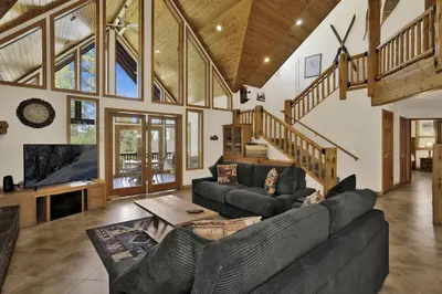 a living room with a couch and a tv at The Village Timber Lodge at Big Bear - Downtown Log Cabin Retreat in Big Bear Lake