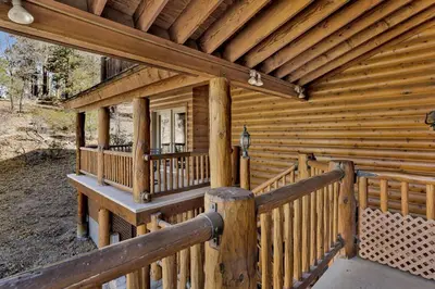 a wooden cabin with a porch and a balcony at The Village Timber Lodge at Big Bear - Downtown Log Cabin Retreat in Big Bear Lake