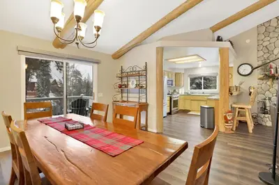 a dining room and kitchen with a wooden table and chairs at Modern Relaxation at Castle Glen Gem Big Bear Lake in Big Bear Lake