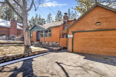 a house with a wooden garage and a tree at Vista Pines at Big Bear Lake– Your Ultimate Mountain Escape in Big Bear Lake