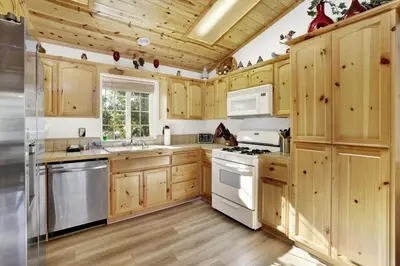 a kitchen with wooden cabinets and white appliances at Lookout Lodge Family Chalet at Big Bear w/ Games in Big Bear City