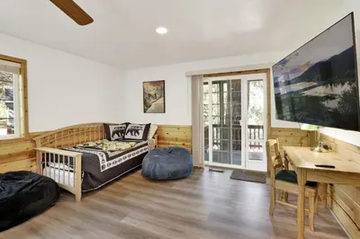 a living room with a couch and a table at Lookout Lodge Family Chalet at Big Bear w/ Games in Big Bear City