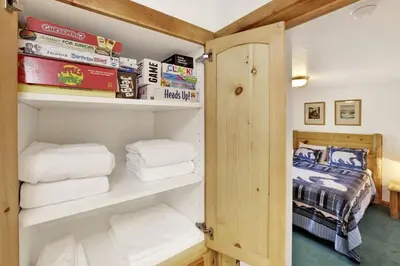 a room with a closet with towels and a bed at Lookout Lodge Family Chalet at Big Bear w/ Games in Big Bear City