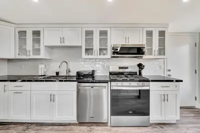 a kitchen with white cabinets and a stove top oven at Incredible View, Huge Pool & Basketball! in Tarzana
