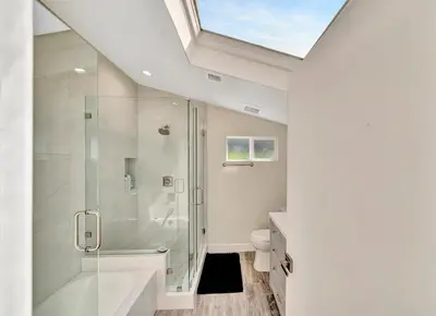a bathroom with a shower and a toilet and a skylight at Incredible View, Huge Pool & Basketball! in Tarzana
