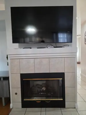 a fireplace with a flat screen tv on top of it at Newly Listed Family Friendly Fontana House in Fontana