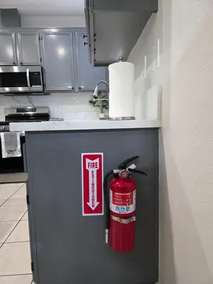 a fire extinguisher is on the side of a refrigerator in a kitchen at Newly Listed Family Friendly Fontana House in Fontana