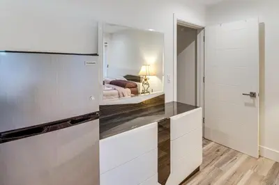 a kitchen with white cabinets and a bed in a bedroom at Luxury guest suite in Los Angeles in North Hills