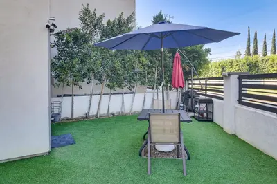 a patio with a table and an umbrella and a chair at Luxury guest suite in Los Angeles in North Hills