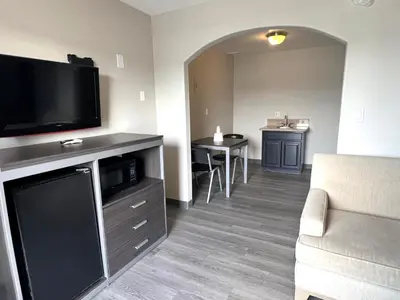a living room with a flat screen tv and a couch at Cloud 9 Inn - El Ciello Inn in Pico Rivera