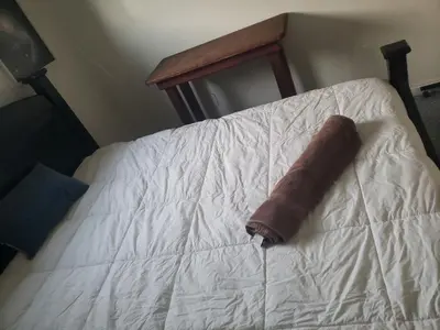 a brown rolled up towel sitting on a bed at Santa Ana Vibes in Santa Ana