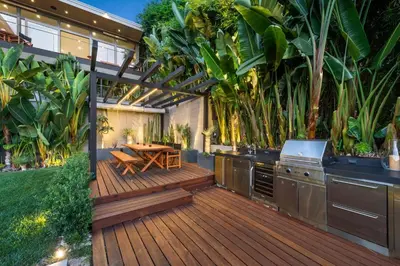 an outdoor kitchen with a wooden deck with a table at Waynecrest in Los Angeles