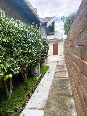 a fence with plants next to a house at Perfect and relaxing Couple retreat in the heart of Los Angeles in Los Angeles