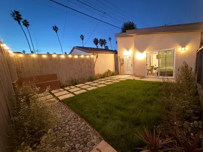 a backyard with a fence and a house with lights at Perfect and relaxing Couple retreat in the heart of Los Angeles in Los Angeles